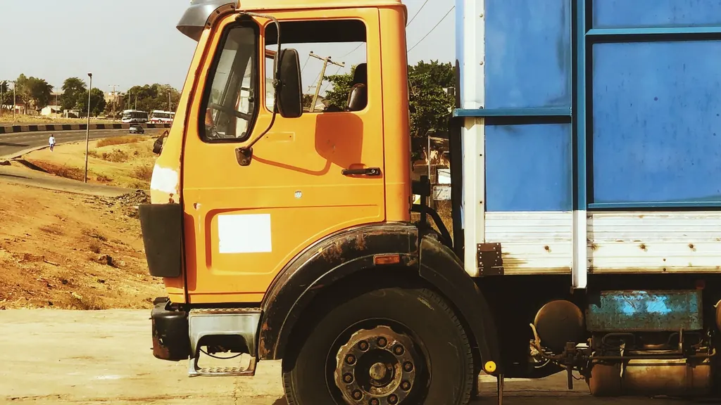 Orange and blue commercial truck on a Nigerian road